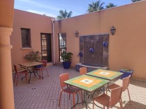 une terrasse avec des tables et des chaises ainsi qu'une cheminée dans l'établissement Chambre Zagora, Riad 8 au village naturiste Couple only, au Cap d'Agde