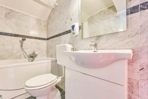 a white bathroom with a toilet and a sink at Hotel Vila Marco Polo in Slatine +59 photos