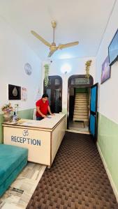 a person sitting at a desk in a room at Hotel Laxman Ganga in Rishīkesh
