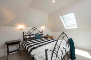 a bedroom with a bed with a black and white comforter at The Old School Historic Stay for 2 Adelaide Hills in Balhannah