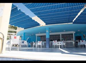 a patio with white chairs and a blue building at Apartamento JÚPITER Vistas in Benalmádena