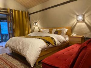 a bedroom with a large bed and a red chair at Dream Nest Resorts in Skardu +21 photos