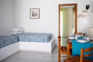 a bedroom with a blue table and a bed at Stefanie Studios in Egina