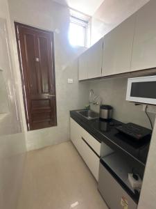 钱德加尔Parkview 33的带水槽和微波炉的小厨房