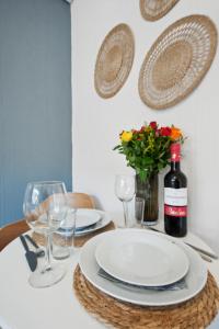 een tafel met borden en glazen en een fles wijn bij Modernes Studio im Erdgeschoss - ZachaStay Koblenz Guels in Koblenz