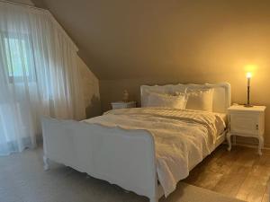 a bedroom with a white bed and a window at Montesse Chalet- La noi la munte in Arada