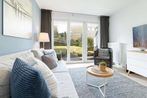 a living room with a white couch and a tv at Meerurlaub in Laboe