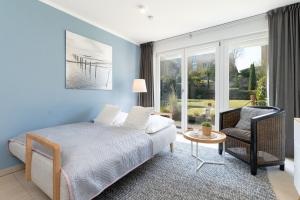 a bedroom with a bed and a chair at Meerurlaub in Laboe