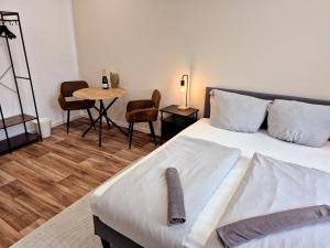 a bedroom with a bed and a table with a chair at Süße Marie 15 in Karlsruhe