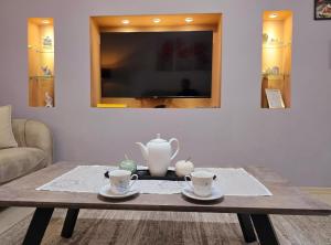 シュコダルにあるGrace's Centre Apartmentの2つのカップとティーポットが置かれたコーヒーテーブル