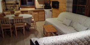 a living room with a couch and a table and a kitchen at Rancho Vaquera in Polanica-Zdrój