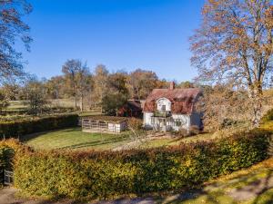 an old house with a red roof in a field at Grimsnas Herrgard in Ljuder