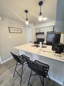 a kitchen with two chairs sitting at a counter at 4 STATE FAIR l DT Dallas l FIFA READY l Staycation 1Bd1Ba in Dallas +9 photos