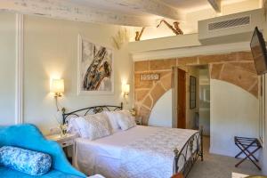 a bedroom with a bed and a blue couch at Son Sant Jordi in Pollença +37 photos
