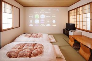 two beds in a room with a large screen at Yokaichi Royal Hotel in Yōkaichi +74 photos