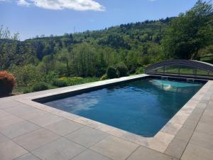 una piscina con un ponte e montagne sullo sfondo di Bâtisse Ardechoise avec piscine a Saint-Prix