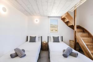 two beds in a room with a staircase at Ocean view villa in Mikonos