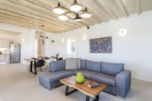 a living room with a blue couch and a table at Ocean view villa in Mikonos
