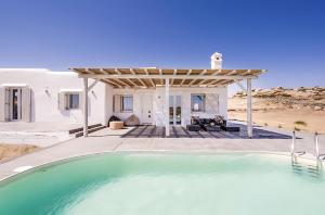a swimming pool in front of a house at Ocean view villa in Mikonos
