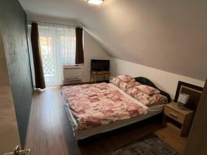 A bed or beds in a room at Talabér Vendégház