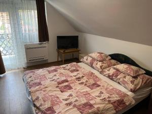 A bed or beds in a room at Talabér Vendégház