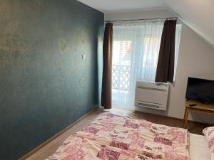 A bed or beds in a room at Talabér Vendégház