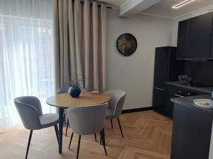 een eetkamer met een tafel, stoelen en een klok bij Apartament Come in in Lubin +11 foto's