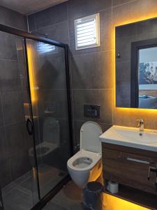 a bathroom with a shower and a toilet and a sink at Başar hotel in Erdemli