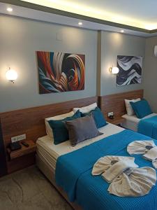 a bedroom with two beds with blue sheets at Başar hotel in Erdemli