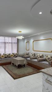 una amplia sala de estar con sofás y una mesa en Appartement Bord de Mer, en Tánger