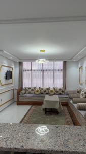 una sala de estar con un sofá y una mesa en Appartement Bord de Mer, en Tánger