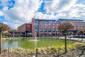 a hotel with a pond in front of a building at Hotel Asteria in Venray