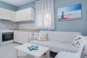 a living room with a couch and a table at Las sirenas maisonnettes by the beach groundfloor and semi basement in Chrysi Ammoudia