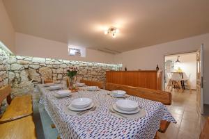 un comedor con una mesa con platos. en Holiday house Cavela, en Gustirna