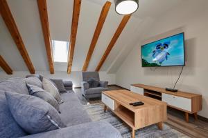 Una sala de estar con un sofá y un televisor. en Holiday house Cavela, en Gustirna