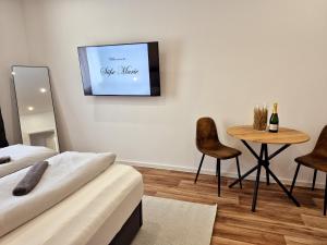 a room with two beds and a table and a tv at Süße Marie 16 in Karlsruhe
