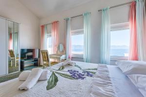 a bedroom with a large bed with a view of the ocean at Hotel Vila Marco Polo in Slatine