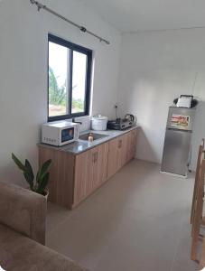 a kitchen with a counter with a microwave and a refrigerator at Evasion Maragon in Saint Gabriel
