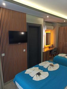 two beds in a hotel room with towels on them at Başar hotel in Erdemli