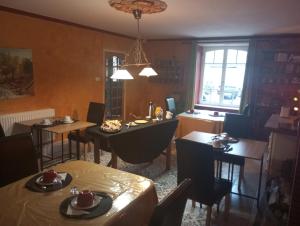 Un comedor con mesas y sillas y una ventana. en chambres d'hôtes proche saint Malo et mont saint Michel, en La Boussac 19 fotos más