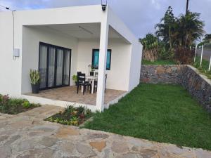 a white house with a patio and a table at Evasion Maragon in Saint Gabriel +6 photos