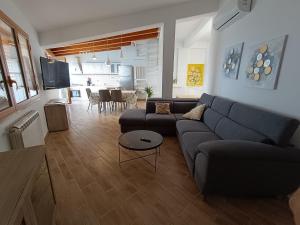 a living room with a blue couch and a table at Finestra sul golfo in Balestrate