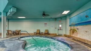 a hot tub in a room with chairs and tables at Plantation Palms 6103 in Gulf Highlands