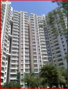 a large apartment building with palm trees in front of it at Greenland Apartment in Pune