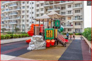 a playground in front of a large apartment building at Greenland Apartment in Pune