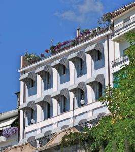 a white building with balconies and flowers on it at Hotel Ideale in Ortona