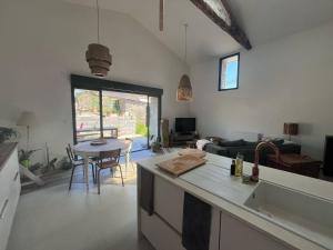 a kitchen and living room with a couch and a table at la maison de Mélissa in Gétigné