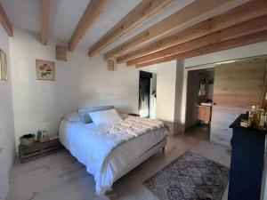 a bedroom with a large bed in a room with wooden ceilings at la maison de Mélissa in Gétigné
