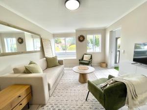 Una sala de estar con un sofá y un televisor. en Green Bay, en Plettenberg Bay