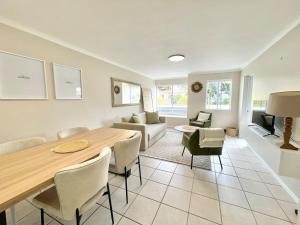 Una sala de estar con una mesa y sillas y un sofá. en Green Bay, en Plettenberg Bay